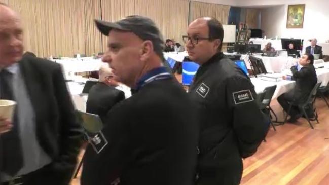 Parramatta councillor Ben Barrak (right) refuses to leave the council meeting last night as two security guards speak with council’s acting CEO, Rik Hart, about it.