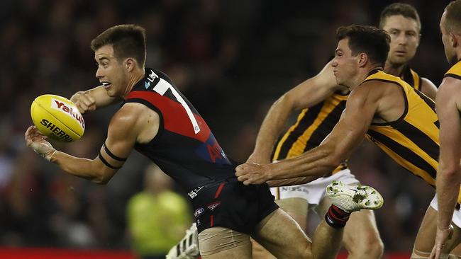 MELBOURNE, AUSTRALIA - MARCH 20: Zach Merrett of the Bombers handpasses the ball under pressure from Jaeger O'Meara of the Hawks during the round one AFL match between the Essendon Bombers and the Hawthorn Hawks at Marvel Stadium on March 20, 2021 in Melbourne, Australia. (Photo by Daniel Pockett/Getty Images)