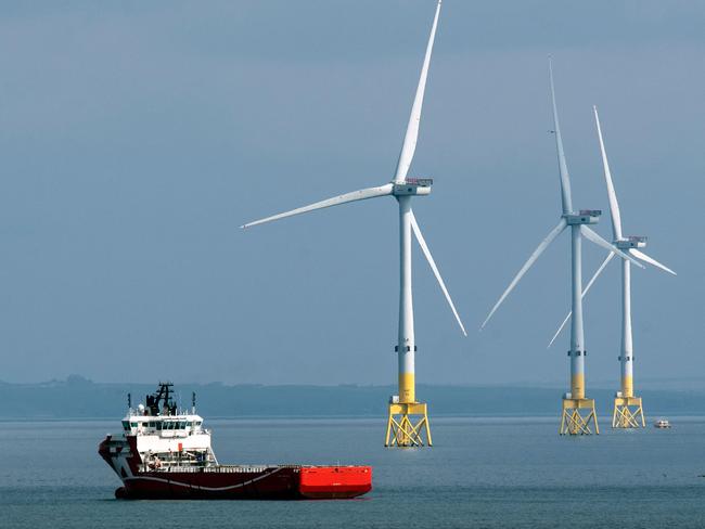 (FILES) A ferry navigates past wind turbines off the coast of Aberdeen in the North East of Scotland, on April 29, 2022. In Europe's oil and gas "capital" of Aberdeen, voters are apprehensive about Labour's plans for combatting climate change if the opposition party wins next month's UK general election as expected. Labour scaled back its green investment pledges under pressure from the ruling Conservatives about how it would fund them, but still promises to make Britain a "clean energy superpower". (Photo by Andy Buchanan / AFP)