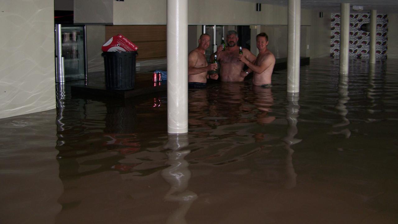 Nigel Jensen, Bruce Dalton and Brett Jensen share a beer at the Spinnaker Bar and Restaurant during the floods. Photo: Contributed.