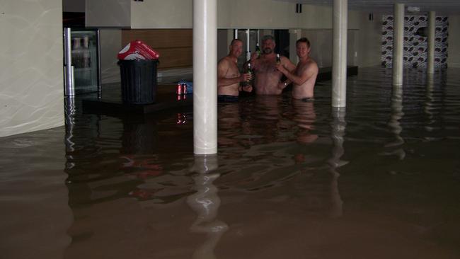 Nigel Jensen, Bruce Dalton and Brett Jensen share a beer at the Spinnaker Bar and Restaurant during the floods. Photo: Contributed.