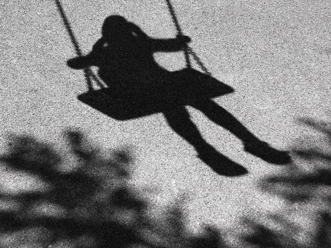 Blurry shadows of girl on a swing and a tree branch