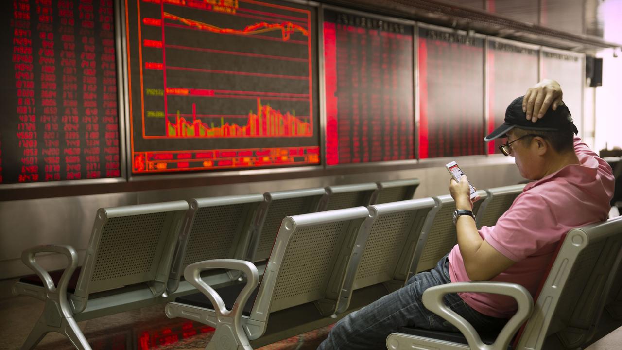 A Chinese investor uses his smartphone as he monitors stock prices at a brokerage house in Beijing on Friday, May 10, 2019. Picture: Mark Schiefelbein/AP