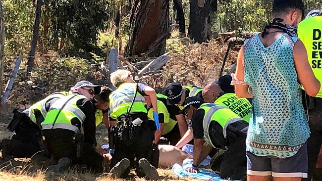 Emergency services attend to a man before he is loaded into an ambulance.  Rainbow Serpent Festival.  Picture: No byline please.