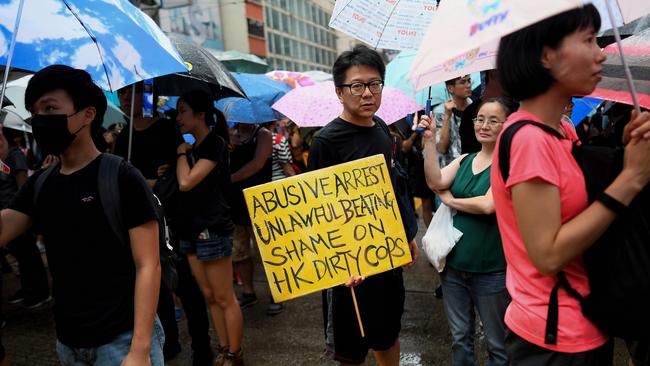 A protester holds up a placard as he and others march during a rally from Victoria Park in Hong Kong. Picture: AFP