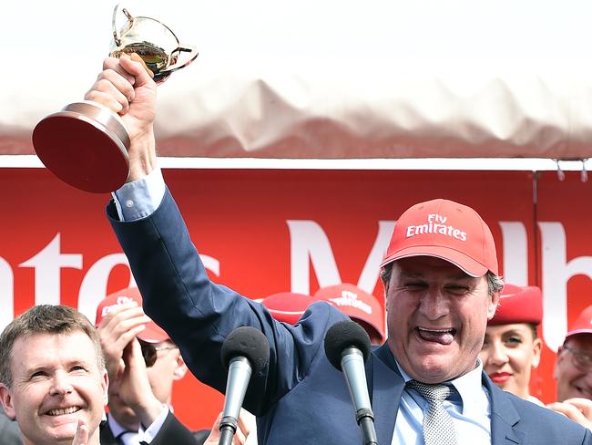 Darren Weir raises the Melbourne Cup winner's trophy after Prince of Penzance’s win.