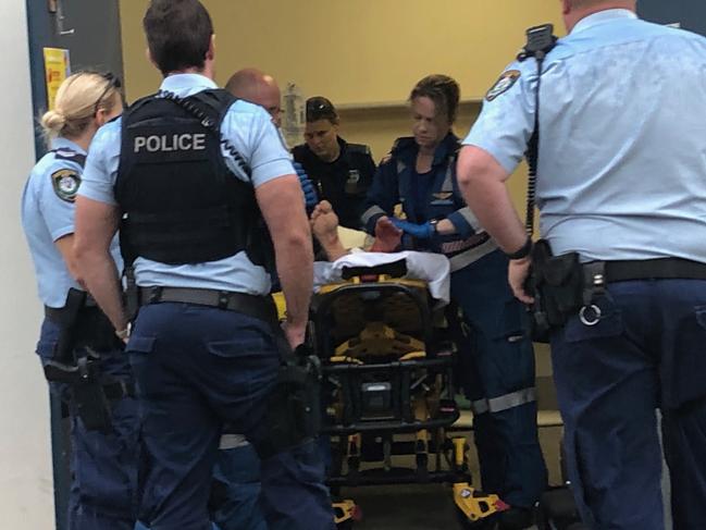 Paramedics treat Mr Schroeter’s foot inside the surf club. Picture: Madeline Crittenden