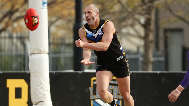 Stephen Brewer fires off a handball for Caroline Springs. Picture: Local Legends Photography