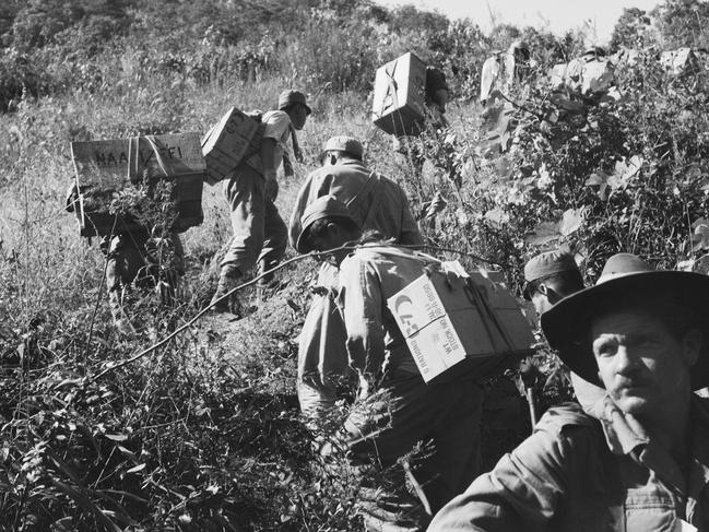 Koreans employed as porters trudge uphill with rations for Australian troops. Picture: Phillip Oliver Hobson/AWM