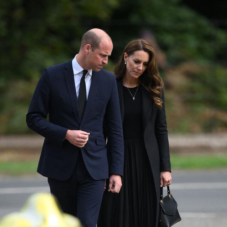 William and Kate look at flowers left for the Queen at Sandringham. (Photo by Daniel LEAL / AFP)