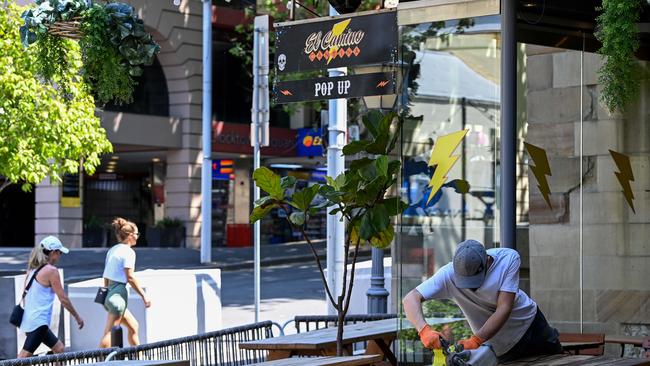 A restaurant employee refinishes the outdoor dining furniture in The Rocks, in Sydney. Picture: NCA NewsWire/Bianca De Marchi