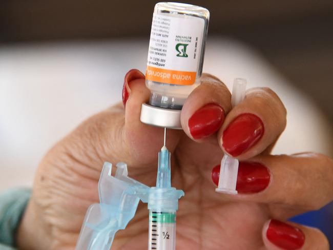 (FILES) A healthcare worker prepares a dose of the CoronaVac COVID-19 vaccine at a drive-thru vaccination post in Brasilia on September 13, 2021. Two years after Brazil began emerging from its pandemic horror show thanks to a massive immunization campaign, officials face a paradoxical predicament: vaccination rates have plunged, and not just for Covid-19, leaving millions exposed to once-eradicated diseases. (Photo by EVARISTO SA / AFP)