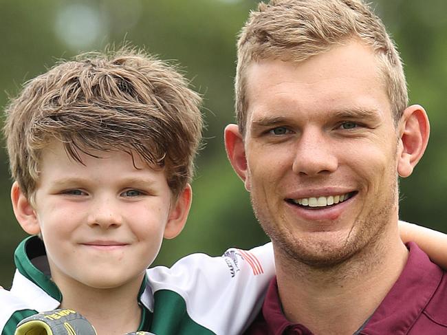 James Wilson (7) who has written an essay about his most inspirational person, which is Manly's Tom Trbojovic, pictured at Forest Rugby Club, Sydney with the boots Tom gave him. Picture: Brett Costello