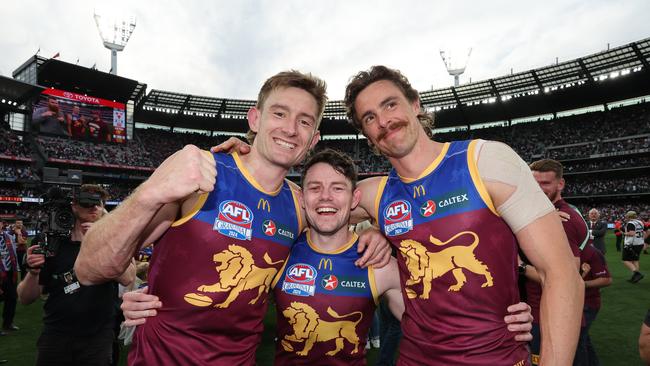 Joe Daniher (right) celebrates Brisbane’s grand final win with teammates Harris Andrews (left) and Lachie Neale. Picture: David Caird