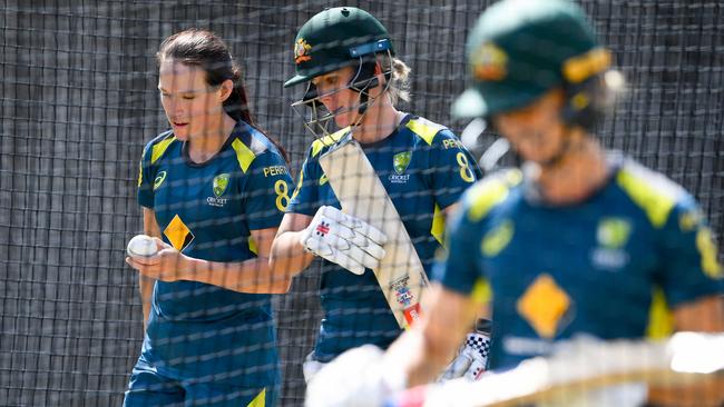 Australia's Megan Schutt (L) and Beth Mooney (C) train in the nets ahead of tonight’s World Cup cricket final. Picture: AFP.