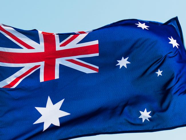 Waving Australia flag against blue sky