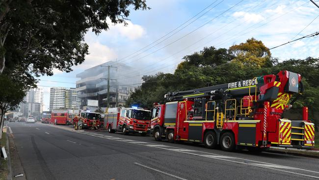 Fire crews line the street at the scene of a house fire in Hamilton. Picture: Annette Dew