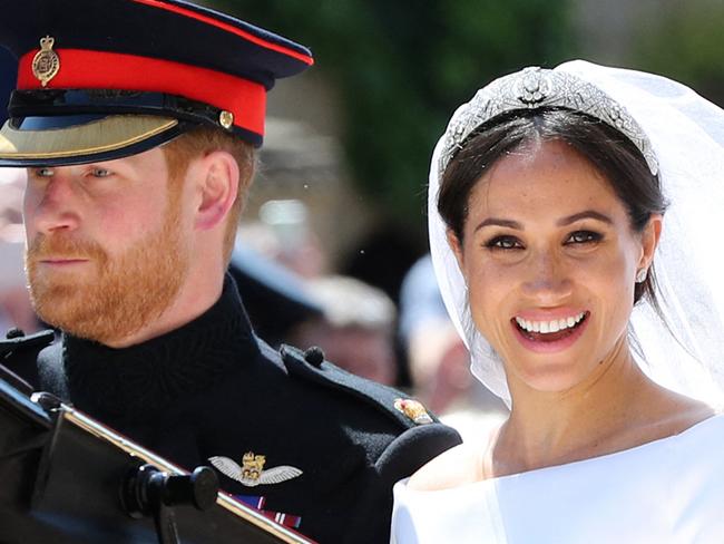 (FILES) In this file photo taken on May 19, 2018 Britain's Prince Harry, Duke of Sussex and his wife Meghan, Duchess of Sussex begin their carriage procession in the Ascot Landau Carriage after their wedding ceremony in Windsor. - Queen Elizabeth II is saddened by the challenges faced by her grandson Prince Harry and his wife Meghan, and takes their allegations of racism in the royal family seriously, Buckingham Palace said on March 9, 2021. "The whole family is saddened to learn the full extent of how challenging the last few years have been for Harry and Meghan. The issues raised, particularly that of race, are concerning," the palace said in a statement released on the queen's behalf. (Photo by Gareth Fuller / POOL / AFP)