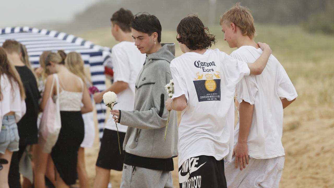 Family and friends of 16-year-old alleged stabbing victim Balin Stewart gather to pay tribute on his home beach at Buddina. Picture: Lachie Millard