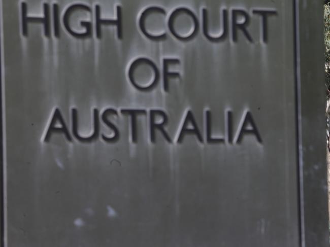 A street sign is seen next to a sign of the High Court in Canberra, Friday, March 8, 2013.  (AAP Image/Lukas Coch) NO ARCHIVING