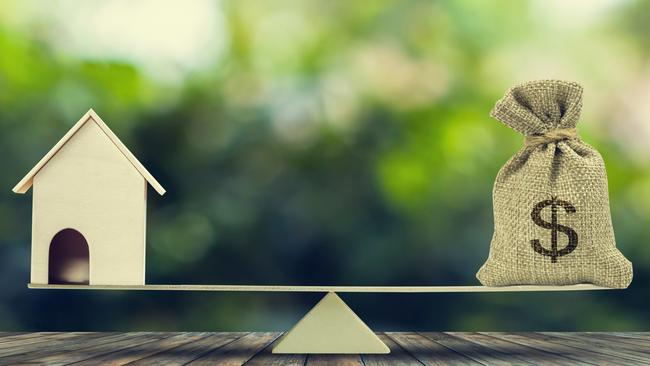 DEPOSIT SAVINGS Money and home,loan,mortgage. Change home into cash concept. US Dollar in sack bag, Wooden house model put on scales on wood table with green tree bokeh as background. Balance home and debt.