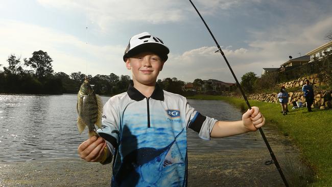 Kayos Hapeta-Williams, 7, from SEQ Carp and Tilly Busters, a group set up to cull pest fish species. Showing off a small tilapia he caught before it was destroyed. Picture: Glenn Hampson.