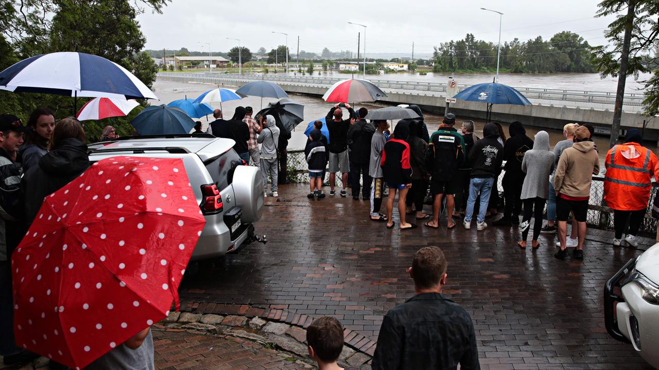 Crowds gather to watch the flooded banks of the Hawkesbury River. Picture: Adam Yip
