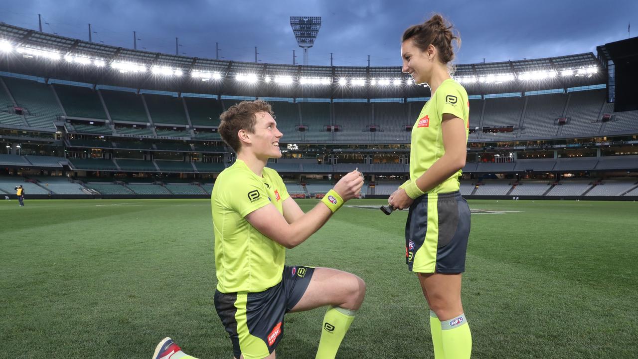 AFL umpire Dillon Tee asks AFL field umpire Eleni Glouftsis to marry him. (AAP Image/David Crosling)