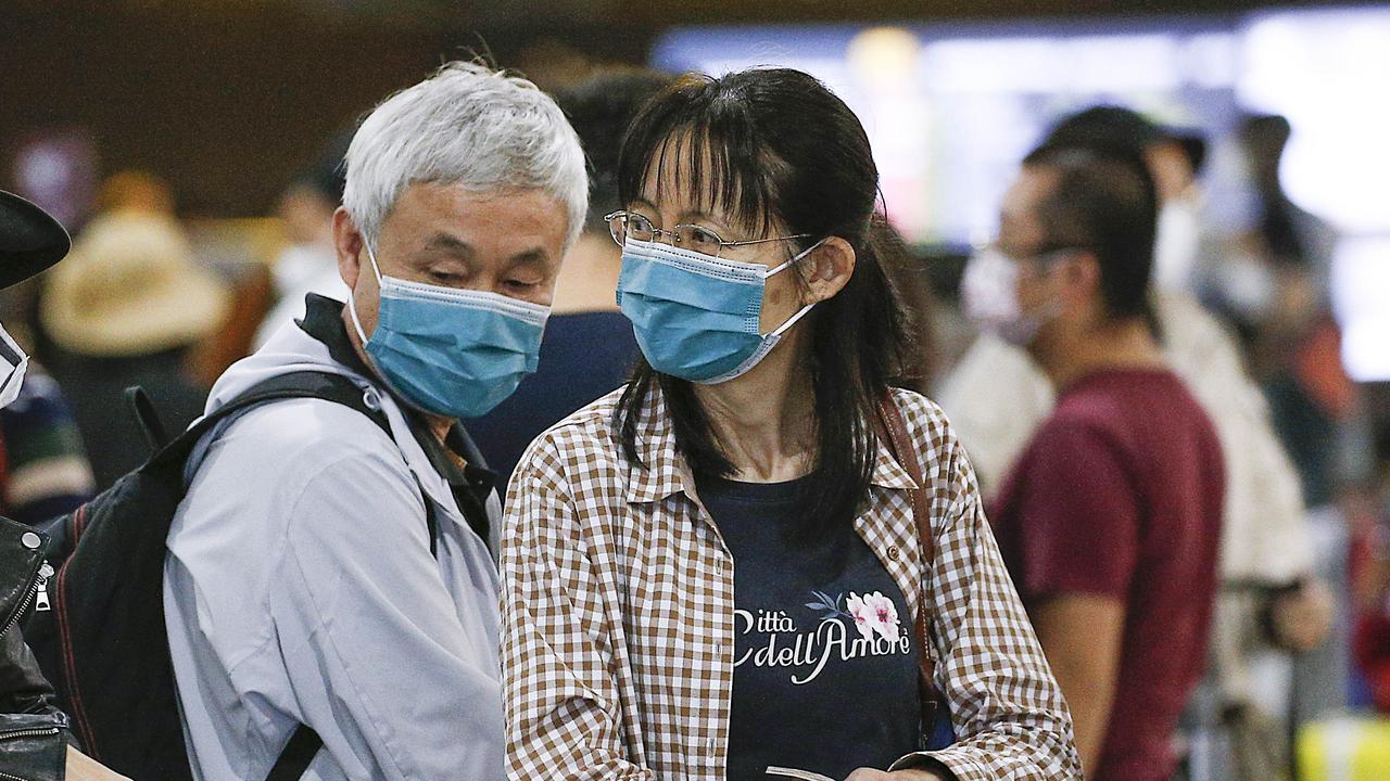 Melbourne Airport travellers wearing masks. Picture: Ian Currie