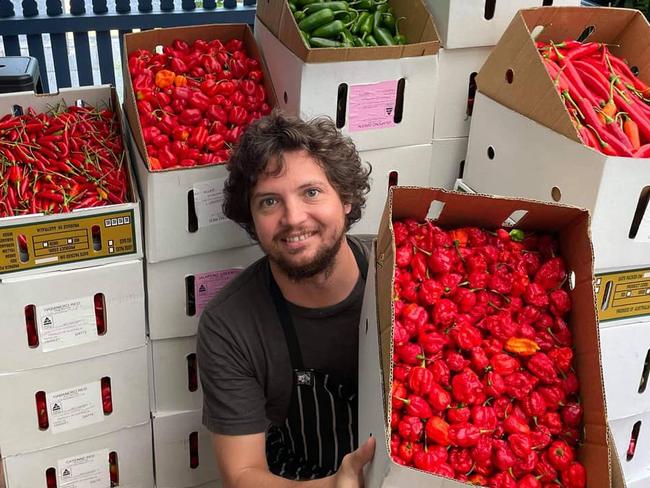 Village Pickle Chili Co co-founder Brendan Chan with the many varieties of chili he uses to make fermented chili sauce. Picture: Supplied