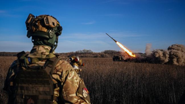 A Ukrainian soldier watches a self-propelled 220 mm multiple rocket launcher "Bureviy" firing towards Russian positions on the front line in eastern Ukraine.