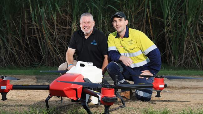 NQ Commercial Drone Services co owners and commercial drone pilots Brian Maher and Gareth Henry with a large commercial drone designed to spray sugar cane crops to deliver a higher yield. Picture: Brendan Radke