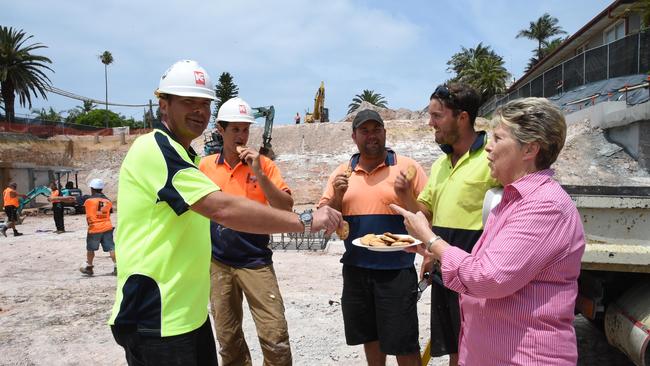 Carolyn Butcher is one of the neigbours that are so excited about a new spinal centre being built in Collaroy, giving biscuits to some tradesmen at the site. Dennis, Coller, Adrian Novaki, Andrew Davies and Tim Spears with Carolyn.