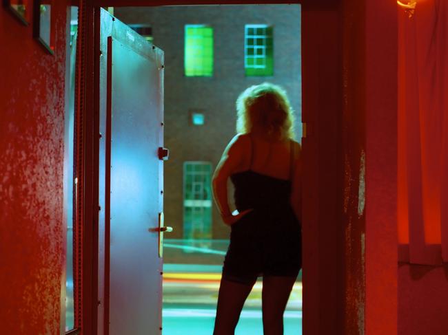 Prostitute Standing in Nightclub Doorway Looking Out