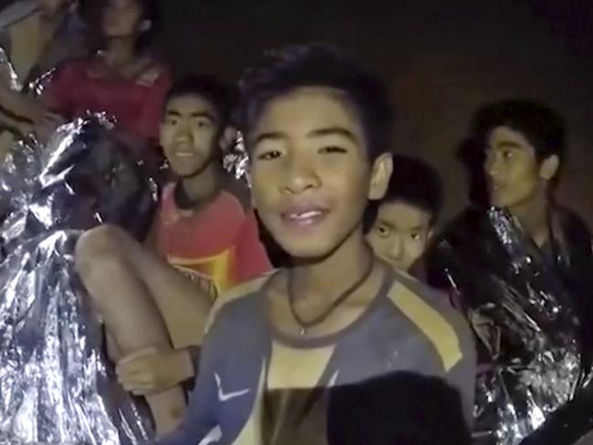 The boys smile as a Thai Navy SEAL medic helps them after they were found trapped in a cave. Picture: Royal Thai Navy Facebook Page via AP, File