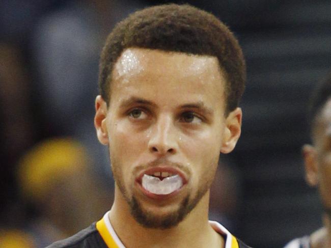 Golden State Warriors' Stephen Curry, second from right, celebrates with teammates Andrew Bogut, left, and Draymond Green after Curry sunk a three-pointer during the second half of an NBA basketball game against the Brooklyn Nets, Saturday, Nov. 14, 2015, in Oakland, Calif. The Warriors beat the Nets 107-99 in overtime. Nets' Thaddeus Young is at right. (AP Photo/George Nikitin)