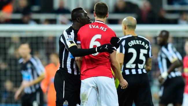 NEWCASTLE UPON TYNE, ENGLAND - MARCH 04: Manchester United player Jonny Evans (r) looks on as Papiss Cisse of Newcastle appears to spit during the Barclays Premier League match between Newcastle United and Manchester United at St James' Park on March 4, 2015 in Newcastle upon Tyne, England. (Photo by Stu Forster/Getty Images)