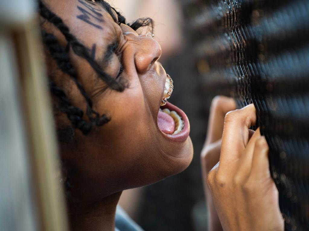 A woman shouts at a line of policemen standing near a metal fence recently erected in front of Lafayette Square near the White House to keep protesters at bay. Picture: Roberto Schmidt