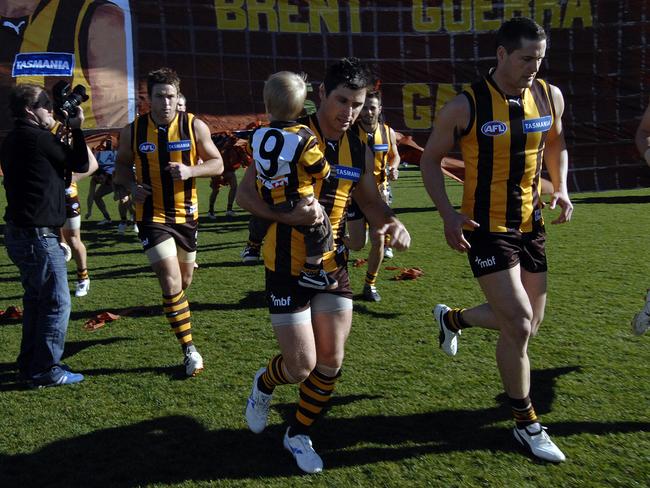 Shane Crawford runs through the banner with son Charlie in his 300th game with the Hawks.