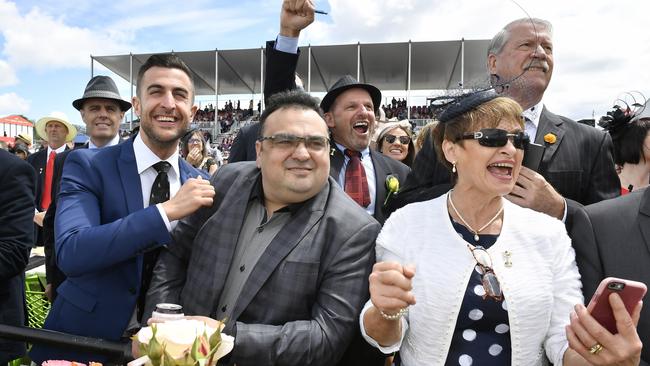 Suited up, frocked up, checking the phones and cheering them home. Picture: AP