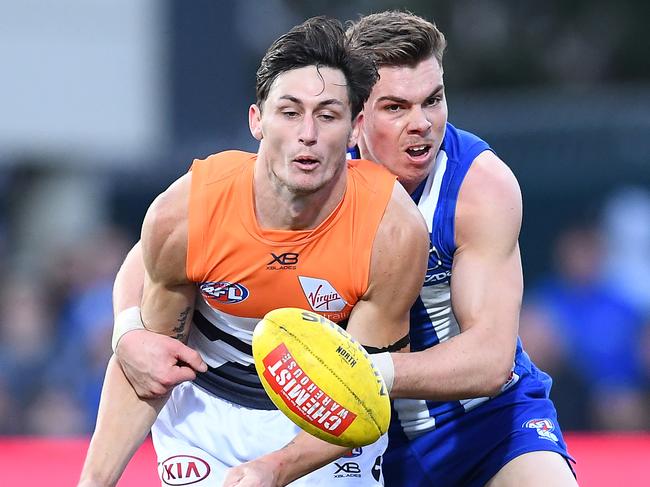 HOBART, AUSTRALIA - JUNE 16: Jake Stein of the Giants handballs whilst being tackled by Cameron Zurhaar of the Kangaroos during the round 13 AFL match between the North Melbourne Kangaroos and the Greater Western Sydney GIants at Blundstone Arena on June 16, 2019 in Hobart, Australia. (Photo by Quinn Rooney/Getty Images)