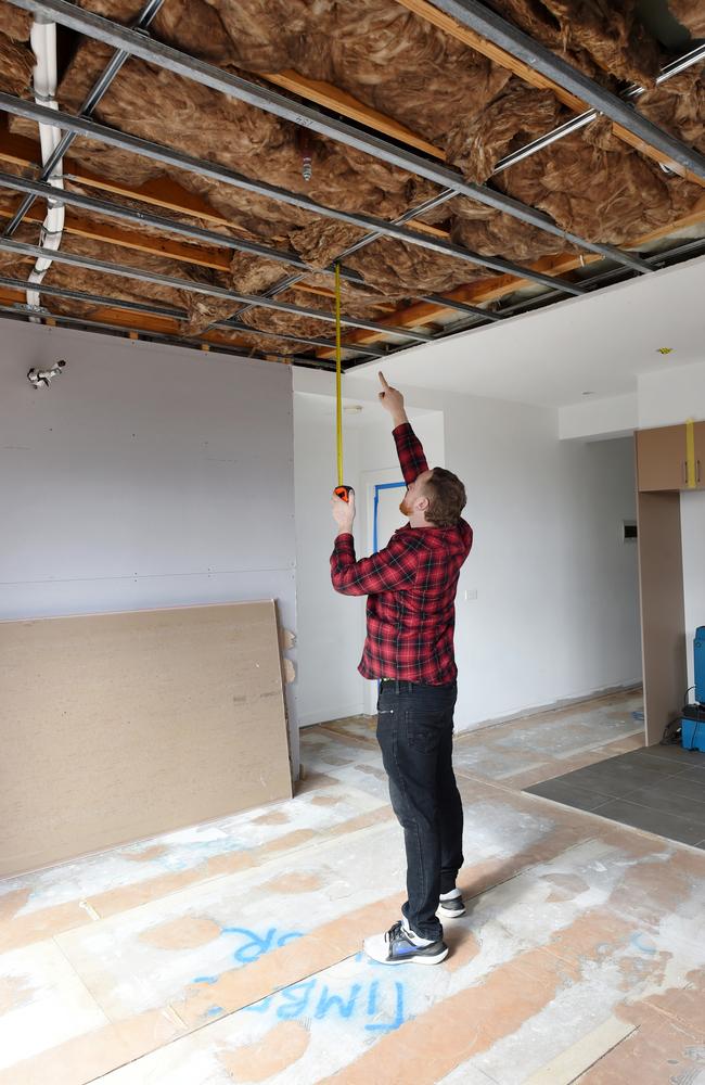 Andrew John points to a ripped up ceiling in one of the defective apartments. Picture: Nicki Connolly/news.com.au