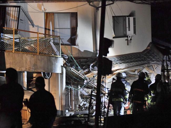 Firefighters search for trapped residents at a collapsed house in Mashiki. Picture: AP