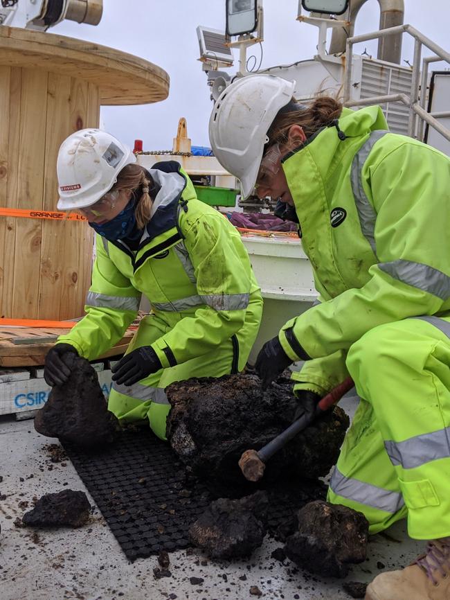 RV Investigator Voyage Manager Margot Hind (left) sorting samples on the back deck of the ship, processing rock samples from a dredge. Picture: Supplied