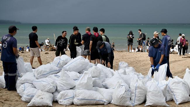 Participants and volunteers remove plastic waste and other garbage washed ashore. Picture: AFP