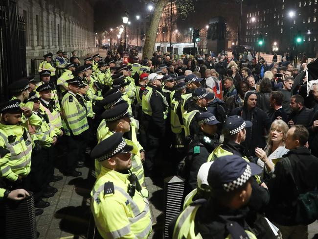 Pro-Brexit supporters (R) face police officers (L) securing the gates of Downing Street in central London on March 29, 2019. - British MPs on Friday rejected Prime Minister Theresa May's EU divorce deal for a third time, opening the way for a long delay to Brexit -- or a potentially catastophic "no deal" withdrawal in two weeks. (Photo by Daniel LEAL-OLIVAS / AFP)