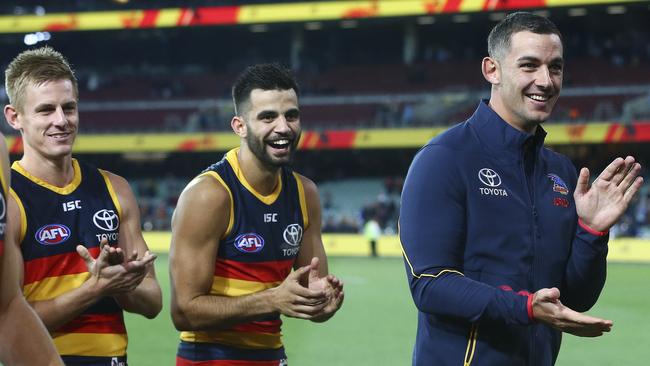 WELL DONE, OTTO: Injured Adelaide captain Taylor Walker acknowledges teammate Andy Otten who led the team off Adelaide Oval on Saturday night following his 100th game. Picture: Sarah Reed.