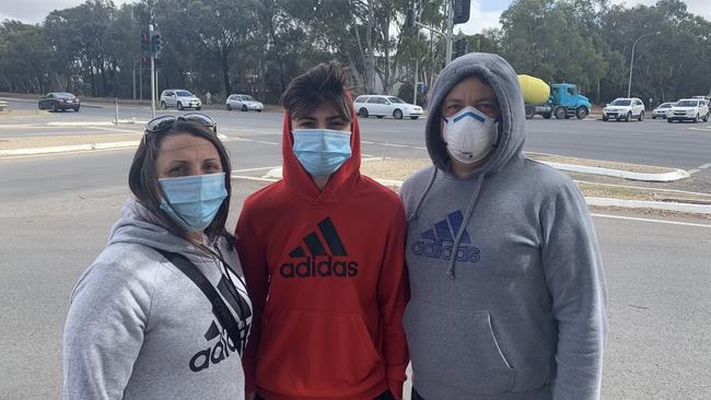 In the Parafield testing line Mario Lupoi (right), whose son (centre) attends Thomas More College, which has been temporarily closed since the northern COVID-19 outbreak. Picture: Ben Cameron