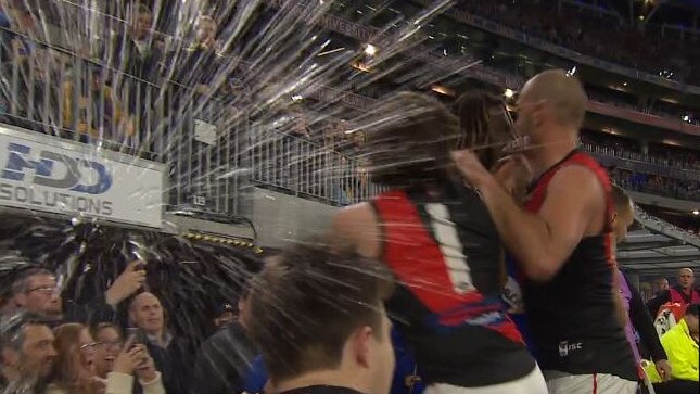 A fan throws beer at Essendon’s Andrew McGrath and Tom Bellchambers.