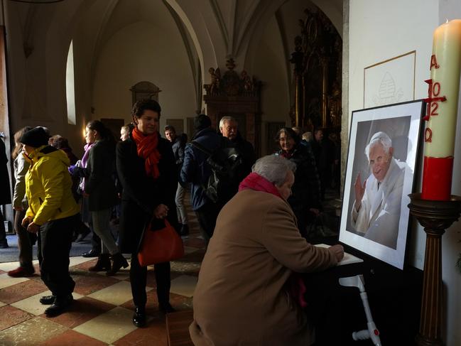 People sign a book of condolence in front of a photograph of former Pope Benedict XVI in the Freising cathedral on January 01, 2023 in Freising, Germany. Picture: Johannes Simon/Getty Images